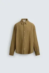 Sobrecamisa color caqui de algodón y lino con efecto arrugado, corte relaxed fit, cuello solapa, manga larga con puños abotonados y cierre frontal con botones.