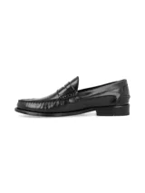 Zapato mocasín de cuero negro con detalle de antifaz y suela plana.