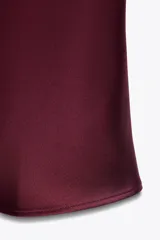 Falda midi color borgoña de satén, de tiro alto y cintura elástica.