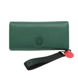 Billetera verde con textura símil cuero, cierre con broche a presión y logo de la marca en relieve. Incluye múltiples compartimentos internos y correa de mano removible con dije de labios rojos.