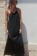 Vestido midi negro de tejido fluido con cuello halter ajustable con lazada.