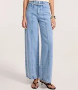Pantalón de jeans de tiro alto, corte wide leg, color celeste claro con costuras verticales marcadas en el frente de las piernas. Incluye un cinturón de tejido a tono.