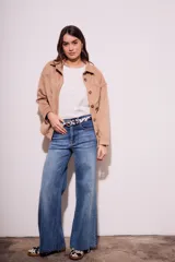 Sobrecamisa negra de gamuza vegana con calce oversize, cuello camisero, cierre con botones a presión, mangas largas con puños abotonados y bolsillos de parche en el pecho.