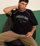 Remera deportiva negra de manga corta con cuello redondo y estampa frontal en relieve con la frase "Alternate Dept Collection Revealing the unknown Powered by Dreamerland".