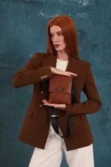 Bandolera tipo phone bag pequeña, color marrón claro, con correa de galón regulable. Tiene un compartimento principal y un bolsillo adicional con tapa.