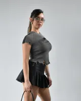 Remera gris de tejido de punto acanalado, con cuello redondo, mangas cortas con detalle desflecado y bajo con roturas.