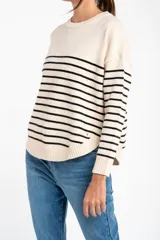 Sweater color crema con rayas horizontales finas color marrón claro, de corte holgado y mangas largas.
