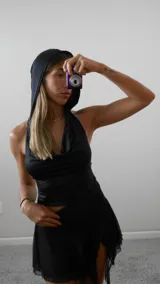 Top negro de lycra con capucha, escote drapeado y espalda descubierta. Se ata en la espalda para regular el talle.