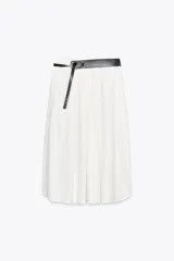 Falda midi color blanco hueso, de tiro alto y corte evasé. Incluye cinturón negro con hebilla metálica.