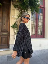 Sweater tejido a rayas verticales en tonos grises y negros, de lana merino y algodón.