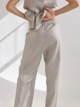 Pantalón de lino color ladrillo, de corte recto con cintura elastizada y tajos laterales en el ruedo.