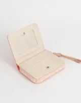 Billetera de tela deportiva colorblock en tonos rosa y beige, con cierre circundante y tirador de cordón y goma.