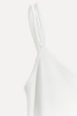 Top lencero blanco con breteles finos y escote redondo.