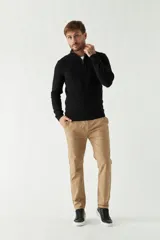 Sweater negro de tejido de punto con cuello alto y medio cierre. Tiene puños y logo bordado.