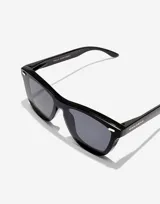 Lentes de sol Hawkers modelo ONE VENM RAW, de la colección Paula Echevarría. Montura cuadrada negra con lentes grises.