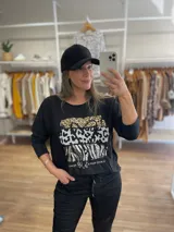 Remera negra de algodón con estampado de animal print en dorado, plateado y gris.