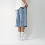 Bermuda de jean celeste con corte ancho y diseño con costuras curvas en los laterales.