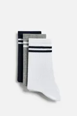 Pack de tres pares de calcetines deportivos de algodón, uno azul marino con dos rayas blancas, uno gris con dos rayas blancas y uno blanco con dos rayas azul marino.