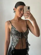 Top de fiesta negro con lentejuelas plateadas, escote en V y tirantes finos.