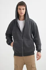 Campera negra con capucha, cierre frontal y bolsillos tipo canguro.