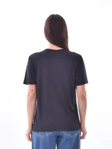 Remera negra de manga corta, corte recto, con estampado frontal que dice "LOVE MORE" con corazones estilizados.