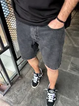 Bermuda de jeans negra con acabado desgastado y corte clásico.