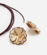 Conjunto de collar de cordón y caravanas con forma de flor con pétalos en capas y detalle en el borde, con baño de oro ligero.