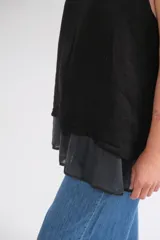 Musculosa negra de lino italiano con cuello redondo, corte holgado, ruedo asimétrico y abertura en la espalda.
