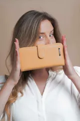 Billetera larga color camel con presilla y broche a presión. Interior con visor, tarjeteros y bolsillos. Compartimento posterior con cierre metálico, incluye bolsillos y monedero con cierre.
