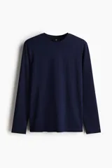 Remera azul marino de punto liviano de mezcla de algodón, de manga larga con cuello redondo ribeteado y bajo recto. Corte ajustado que realza el contorno del cuerpo creando una silueta entallada.