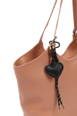 Cartera negra tipo shopper con textura símil cuero, doble asa de hombro y llavero colgante con forma de corazón.