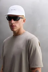 Camiseta deportiva color beige confeccionada en tejido con estructura, ligero y elástico en todas direcciones. Tiene cuello redondo, manga corta, costuras planas y logo estampado en el bajo.