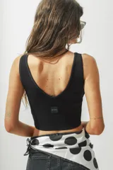 Top corto color crema, de tejido de punto acanalado, con escote en V y breteles anchos.