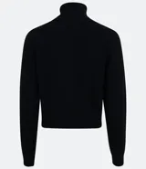 Blusa de punto color blanco, con cuello alto, manga larga y diseño liso.