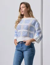 Buzo calado de acrílico, marca Sioni, color celeste y blanco, con cuello a la base y mangas tres cuartos.