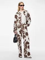 Pantalón de jean ancho con estampado de cebra en tonos marrones y blancos.