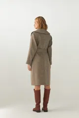 Tapado largo color beige con diseño de espiga, cuello solapa, cierre cruzado con cinturón y bolsillos laterales. Confeccionado en lana fina sin teñir.