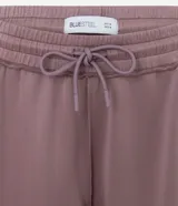 Pantalón recto color rosado, confeccionado en modal, con cintura elástica y ajuste por cordón delantero. Presenta una caída suelta en las piernas y bajo sencillo.