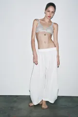 Bralette de encaje color gris con escote en V y doble tirante. Cierre trasero con gancho metálico.