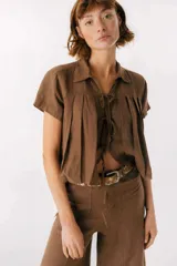 Camisa celeste de lino con cuello clásico, mangas cortas, corte crop y lazos en el frente.