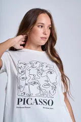 Remera blanca de algodón con cuello redondo y estampado frontal con diseño artístico de rostros en líneas negras y texto "PICASSO The Museu Picasso Barcelona, Spain".