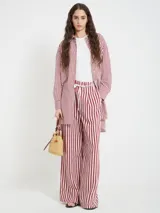 Pantalón de viscosa con rayas verticales rojas y blancas, corte recto, cintura elástica con cordón decorativo.