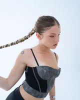 Top tipo corset de color gris con textura y paneles laterales negros.