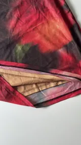 Minivestido con estampado floral en tonos rojos y negros, con escote halter de encaje negro.