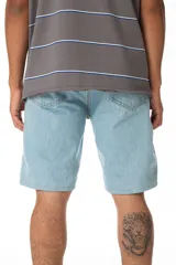 Bermuda de jean celeste, corte recto, largo hasta la rodilla, con costuras contrastadas, parche trasero de ecocuero con logo y confeccionada en Uruguay.