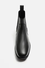 Bota Chelsea de cuero negro, con elásticos laterales, tirador trasero y suela con ligero tacón.