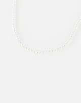 Gargantilla choker de perlas blancas con cadena dorada ajustable.