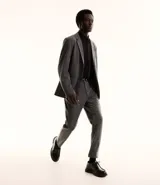 Pantalón de vestir gris de corte slim fit, con trabillas en la cintura y cierre por botón y cremallera. Confeccionado con tecnología performance que se arruga menos y seca más rápido.