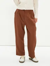 Pantalón marrón de corte amplio, con pinzas en la cintura y cierre con botón.