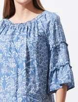 Blusa celeste con estampado floral blanco, escote con frunces y mangas 3/4 con volados.